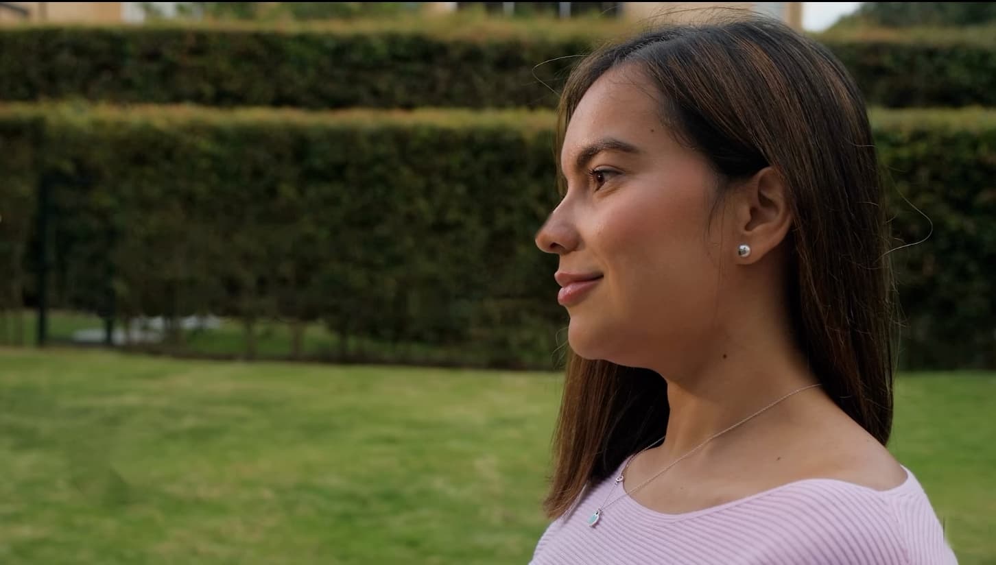 Angélica Cabrera de perfil, en un jardín con luz de tarde.